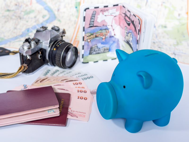 Piggy bank with dream destination sketch, passport book/ concept of savings for holiday travelling